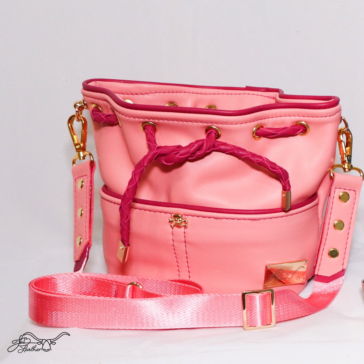 Mini Drawstring Crossbody in coral pink leather with dark pink piping