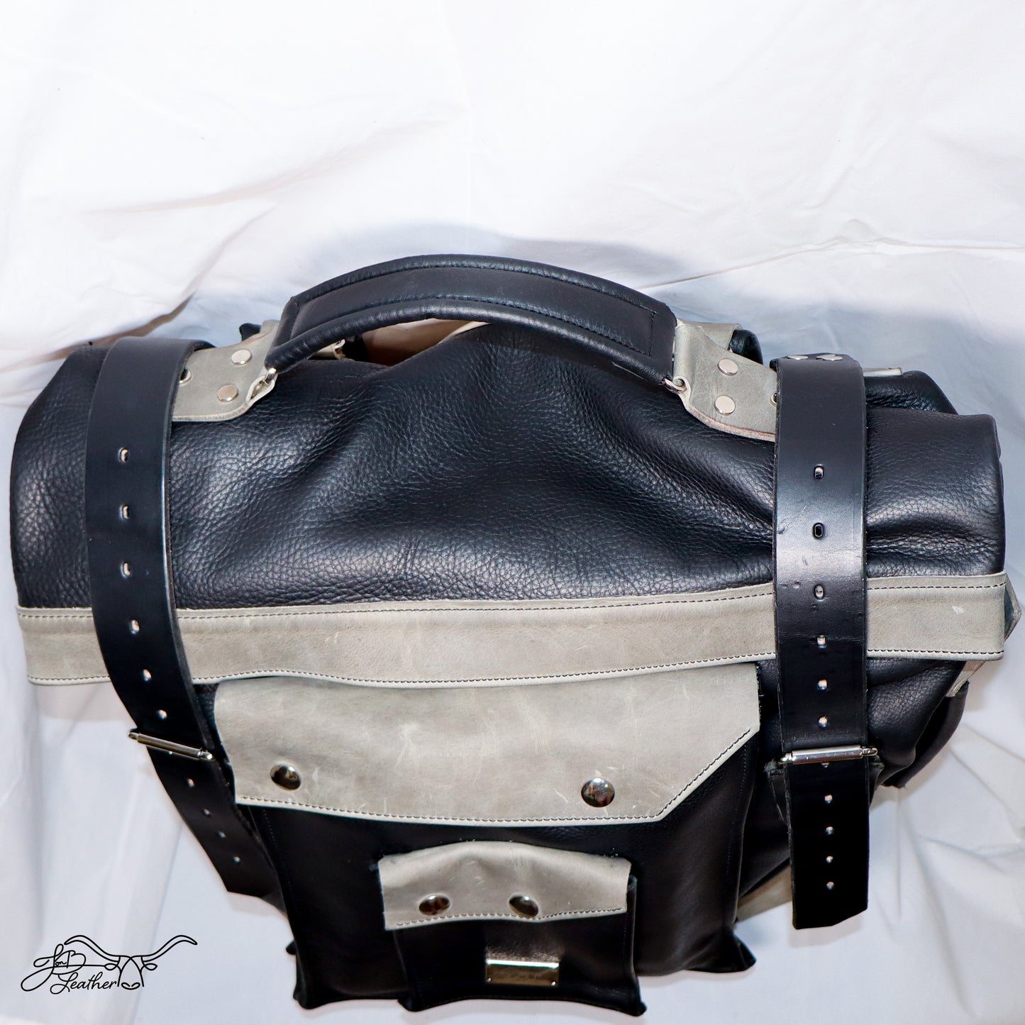 Leather backpack worn on shoulders for travel use showing top handle