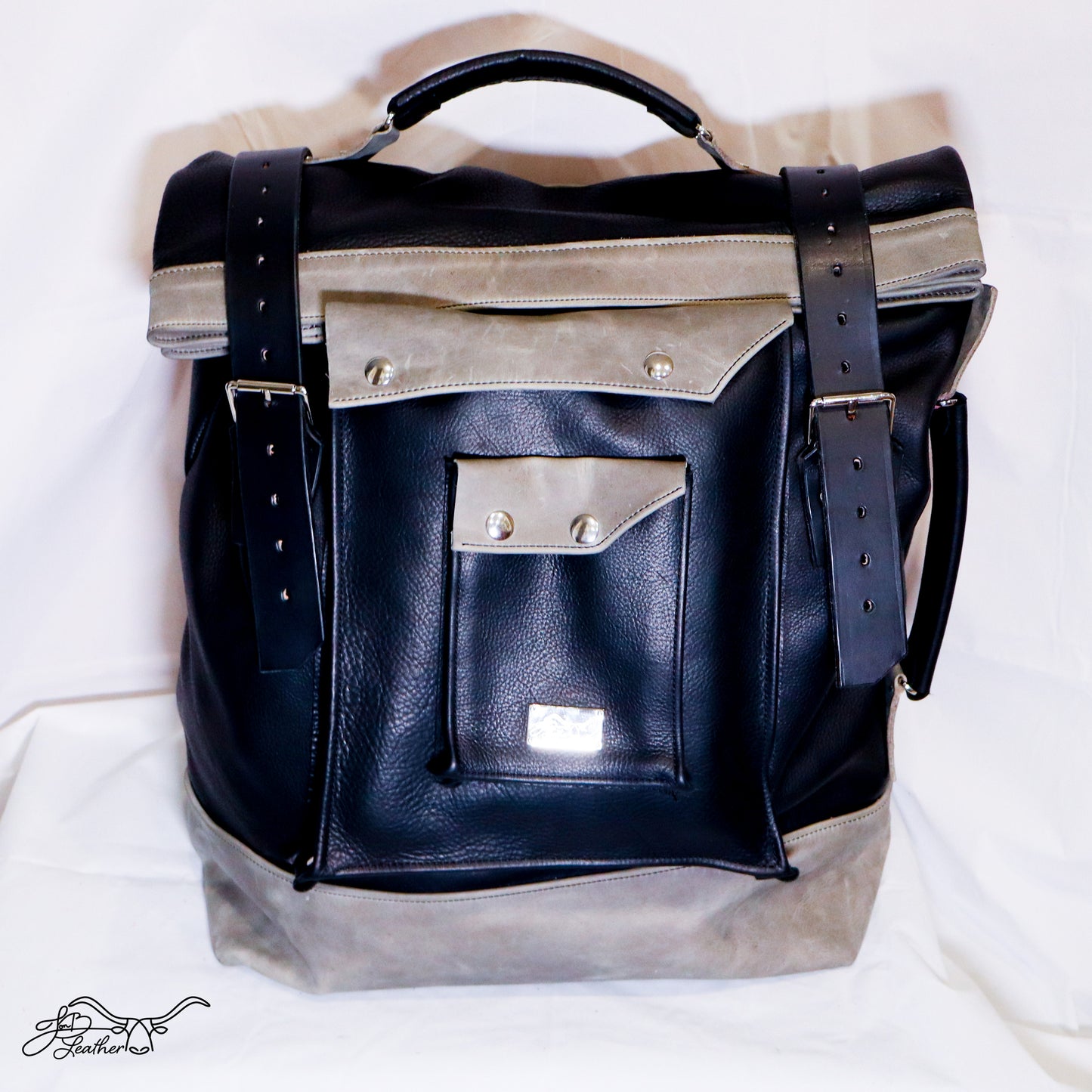 Buckle straps securing roll top leather backpack