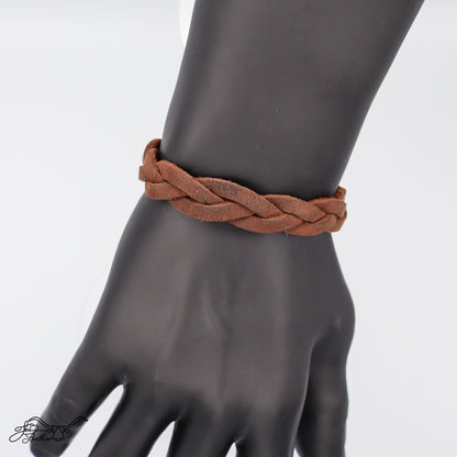 Close-up of a Brown braided bracelet on a black mannequin hand against a white background