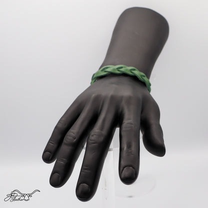 Black mannequin hand with a green braided bracelet against a white background