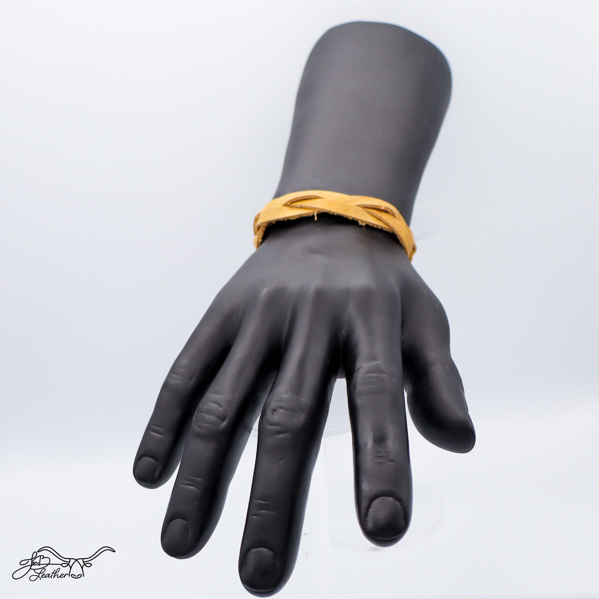Black mannequin hand with a yellow bracelet against a white background
