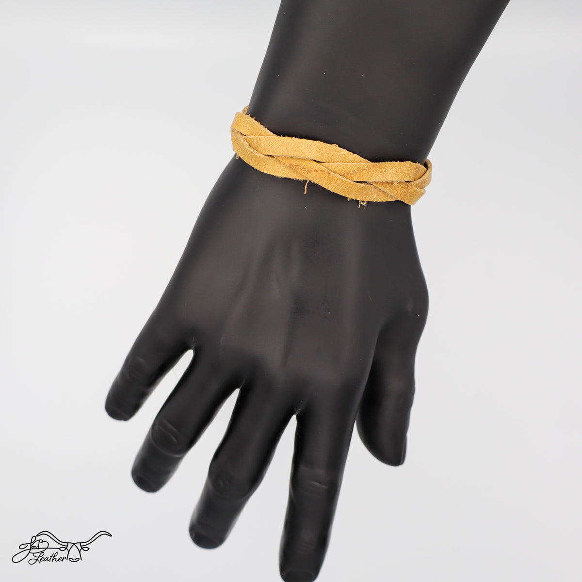 Blonde braided bracelet on a black mannequin hand against a white background